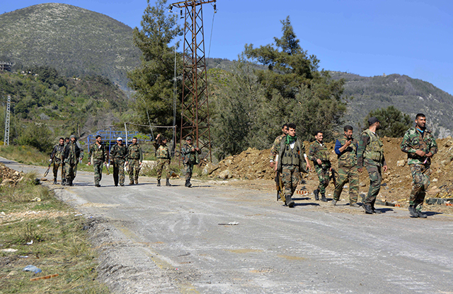 Pro-regime soldiers are seen marching on a road in the village of Kasab, in the northwestern province of Latakia, on March 27, 2014. Photo: FP PHOTO/AFP/Getty Images